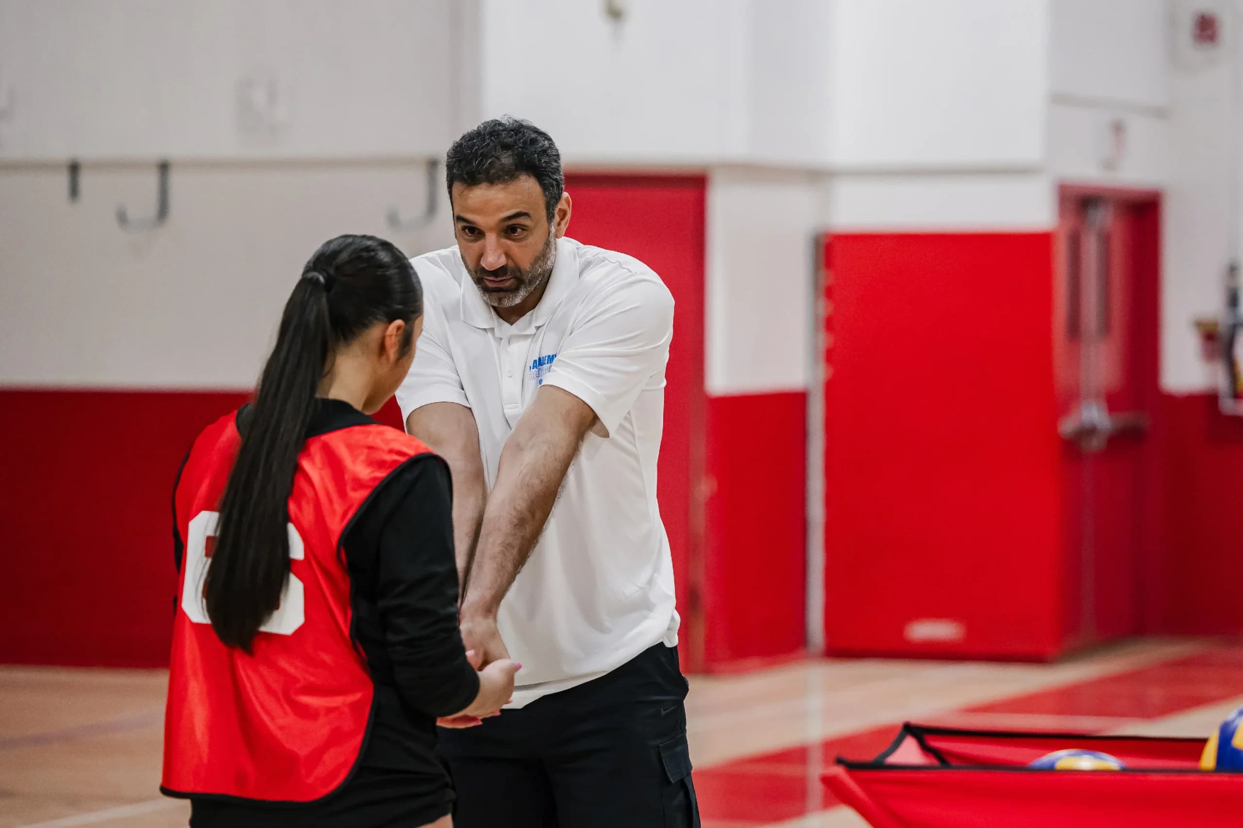 RVA coach providing one-on-one youth volleyball training feedback